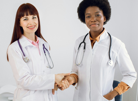 Two newly qualified medics female shaking hands