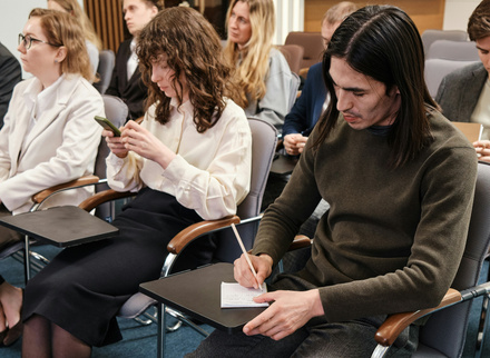 Man sitting on a conference chair writing